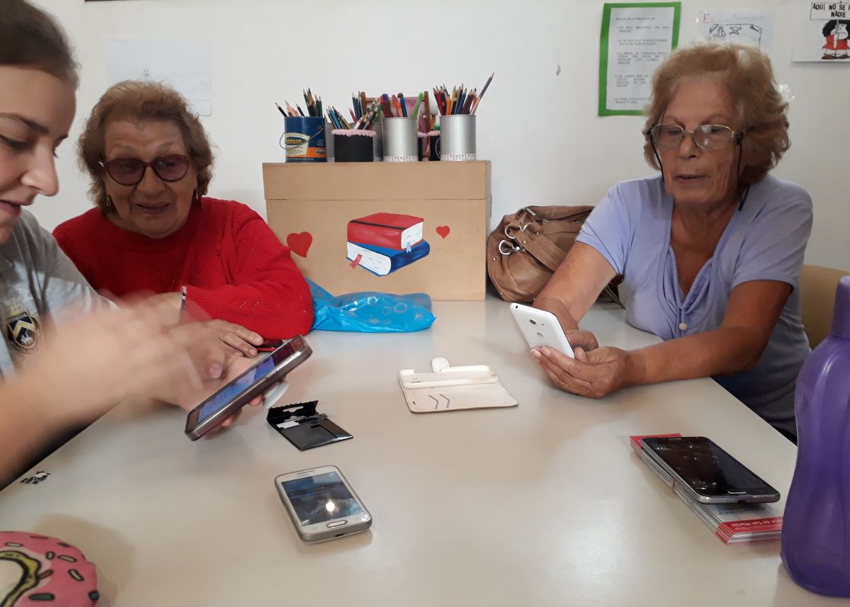 Photo of Los participantes del programa Conectándonos en la Biblio (Connecting in the Library) aprenden a usar la tecnología móvil