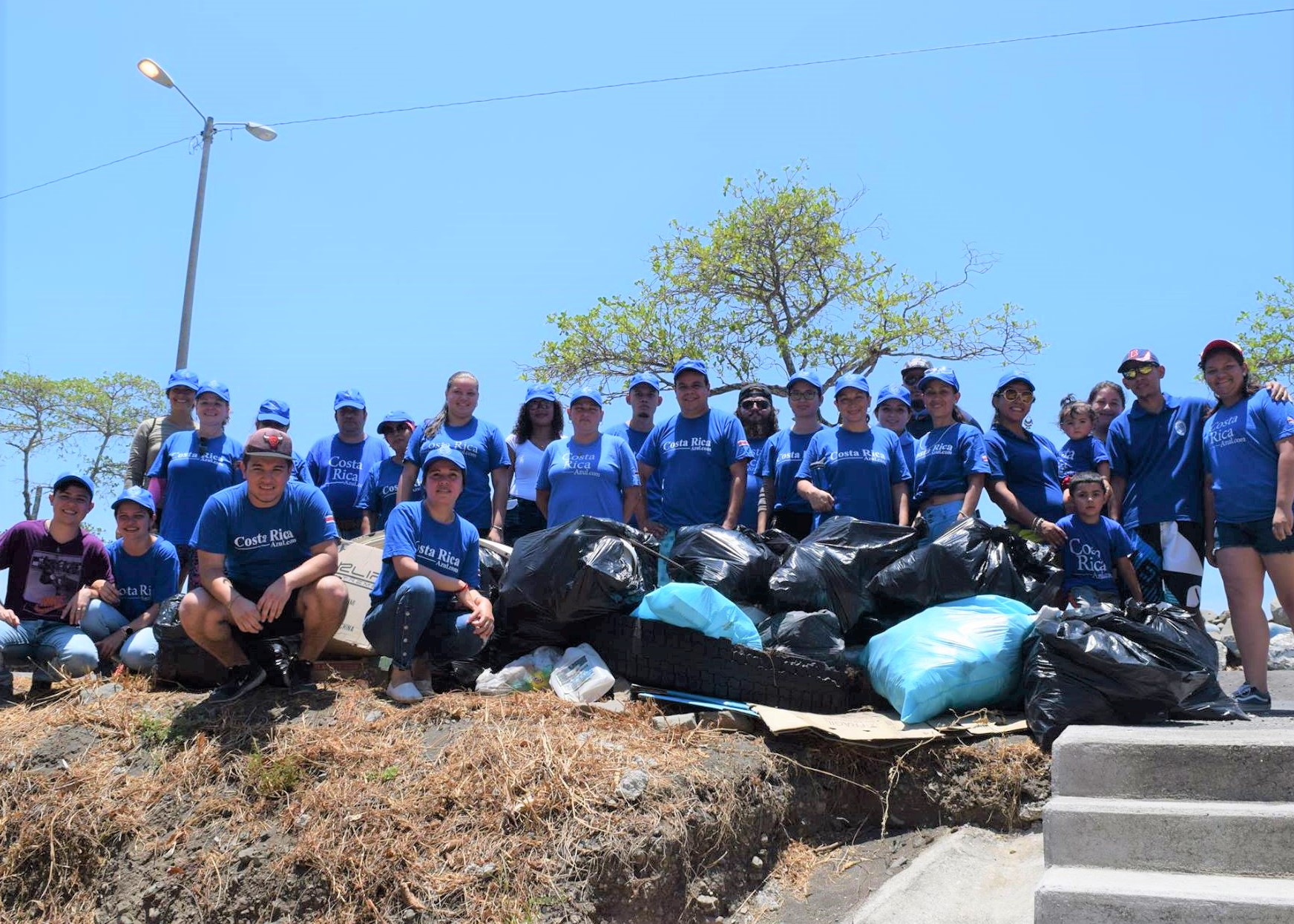 Photo of Un grupo de bibliotecarios y miembros de la comunidad con bolsas de basura recogidas de la playa en Caldera